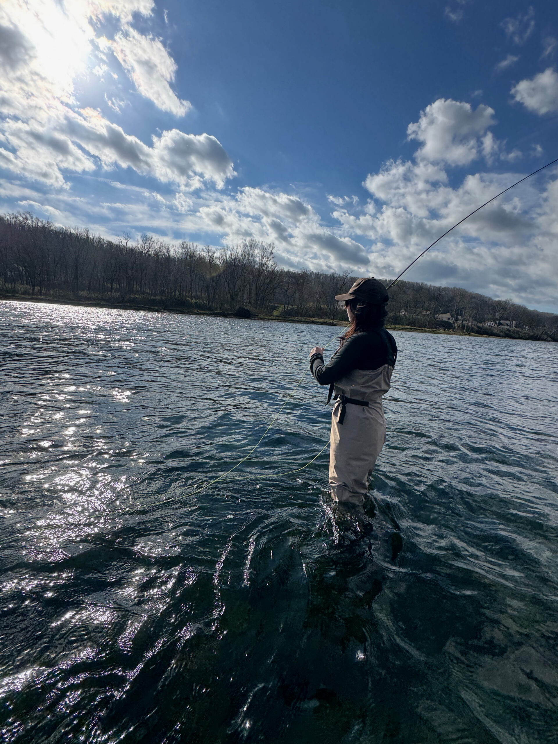 Young Woman Fly fishing wading on the white river