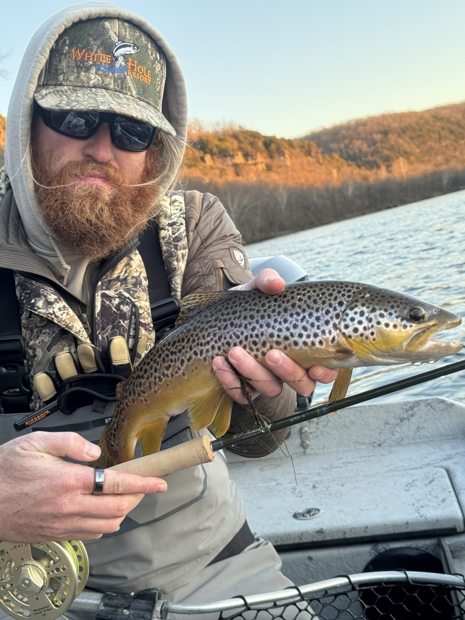 White Hole Resort Owner, Bailey Short holding a brown trout